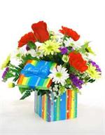Send a present with true presence. Our fresh bouquet of red roses, red carnations,yellow and white daisies mums with yellow solidago, purple statice, million star baby breath and more, beautifully designed in a ceramic gift box with matching lid and bow 