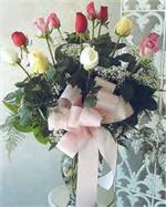 One dozen mixed color, long stem roses in a glass garden vase trimmed with million star gyp, tree fern, baker fern, and salal tips.