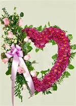A Place in our Hearts. This large open heart is covered with lavender spray daisies, and outlined with salal leaves and leather leaf . Accented on the left side of the heart is a spray of ten pink roses with mixed greens, baby breath, wax flower, baby euc