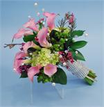 Pink Calla Lillies with green hydrangeas, pink wax flower, green hypericum berries, white pearls, and tied with dazzle ribbon