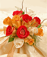 Beautiful nosegay of red roses with shades of orange colored roses with green hypericum and salal tips.