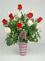 Our ceramic vase with a candy cane design, holds six holiday red roses with six snow white roses all arranged with a mix of holiday greens, pine cones, holly and white sun spring aster