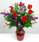 She’s always been the girl of your “Dreams” so this Valentine’s Day show her just how important she is to you. This valentine red glass garden vase is filled with red roses, pink, white, and red tulips, purple statice, mixed greens and lavender asters. Ju