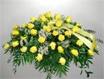 This bright and beautiful casket spray  with its yellow roses, baby breath and soft foliage, and matching yellow ribbons, offers the notion that love is eternal.