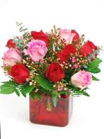 Not only is the rose the national flower, it also is everyone favorite flower. This ruby glass cube glass vase is filled with six pink roses and six red roses with mixed greens and highlighted with pink wax flowers, and baby blue eucalyptus. 