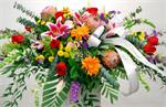 Arranged with red roses, stargazer lilies, orange gerbera daisies, pink frost proteas, purple statice, baby eucalyptus, yellow button pomps and mixed greens. This bright and beautiful casket spray offer the notion that the memory of many happy times toget