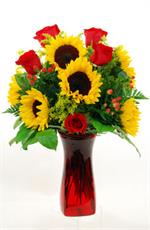 Bold bright and colorful are just a few words that describes our Sunset design. Designed in a ruby red glass vase are golden yellow sunflowers, with large red roses, yellow solidago, hypericum berries, baker fern and salal. Welcome the colorful autumn sea